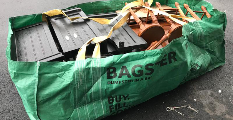 Bagster dumpster bag filled with cabinets and wood furniture.